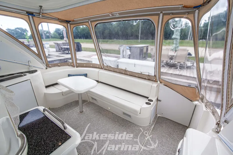 Slide: The Image of 2006 Cruisers Yachts 420 Express interior with seating and table, featuring clear enclosure. - 28