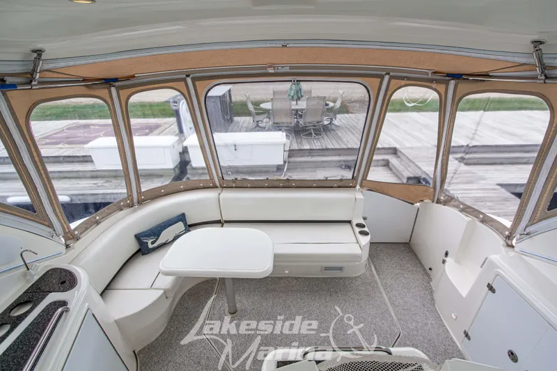 Slide: The Image of 2006 Cruisers Yachts 420 Express interior with seating and table, dockside view. - 29