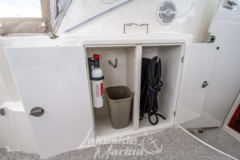 Slide: The Image of Open storage compartment on 2006 Cruisers Yachts 420 Express with fire extinguisher and rope. - 30