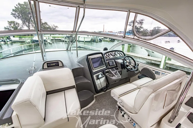 Slide: The Image of 2006 Cruisers Yachts 420 Express helm with modern controls and waterfront view. - 39
