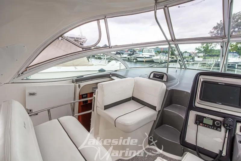 Slide: The Image of 2006 Cruisers Yachts 420 Express interior with helm, seating, and marina view. - 40