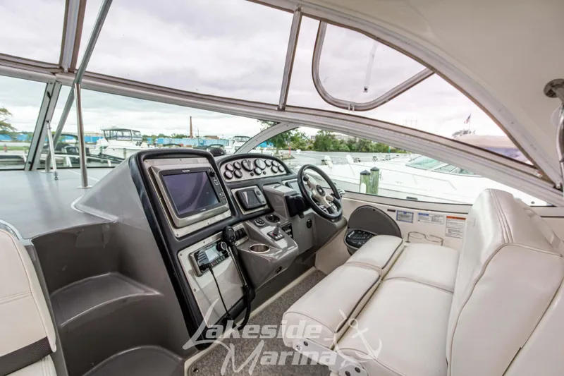 Slide: The Image of 2006 Cruisers Yachts 420 Express helm with modern navigation equipment and comfortable seating. - 41