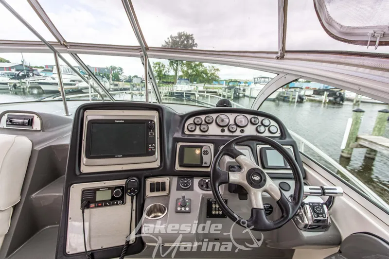 Slide: The Image of 2006 Cruisers Yachts 420 Express helm with navigation controls at marina. - 45