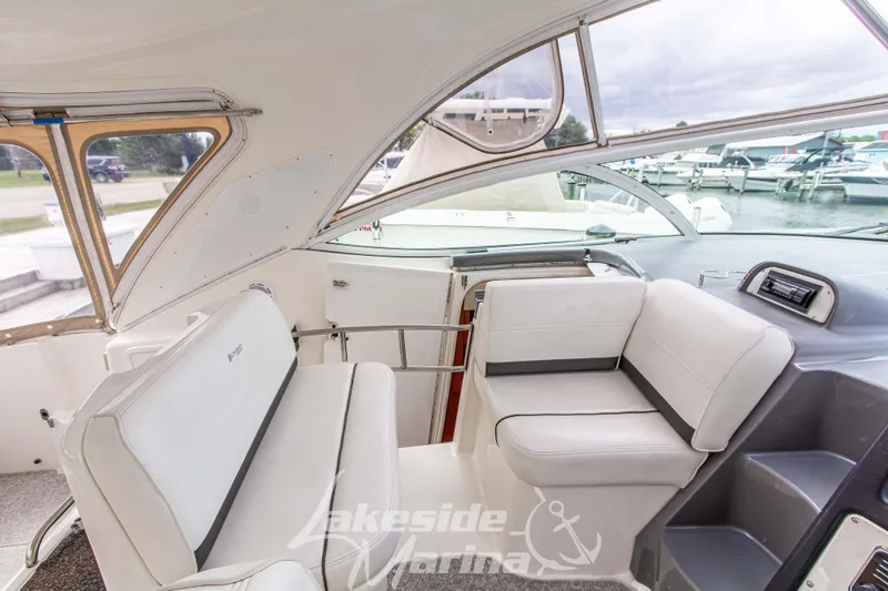 Slide: The Image of 2006 Cruisers Yachts 420 Express interior with white seating and marina view. - 57