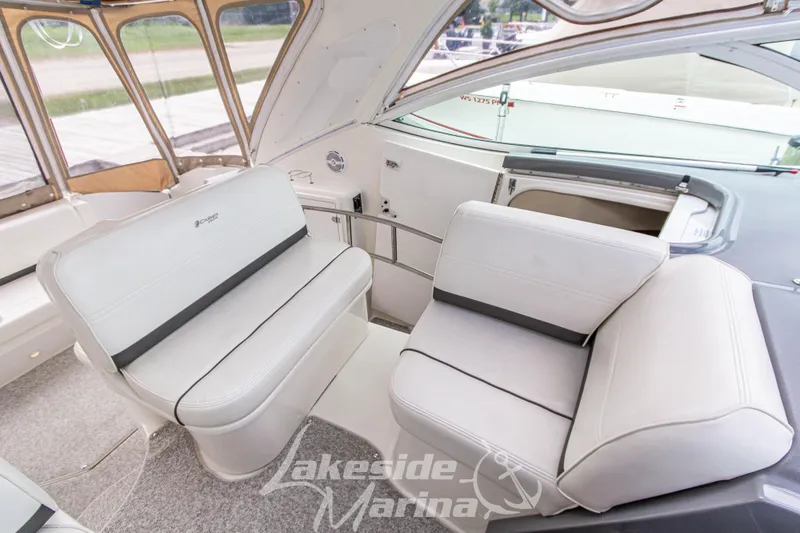 Slide: The Image of 2006 Cruisers Yachts 420 Express interior with white seating and marina view. - 58