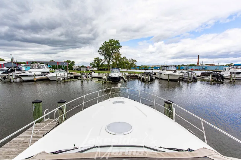 Slide: The Image of 2006 Cruisers Yachts 420 Express docked at a marina under cloudy skies. - 66