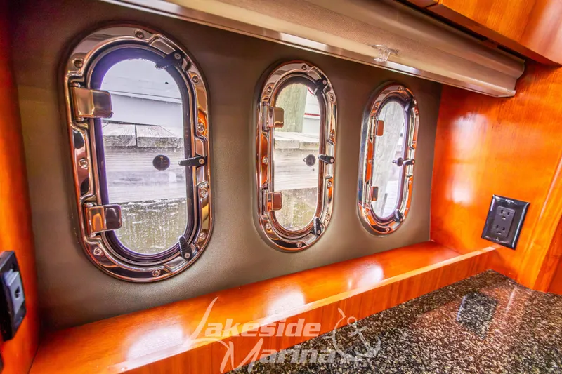 Slide: The Image of 2006 Cruisers Yachts 420 Express interior with porthole windows and wood finish. - 75