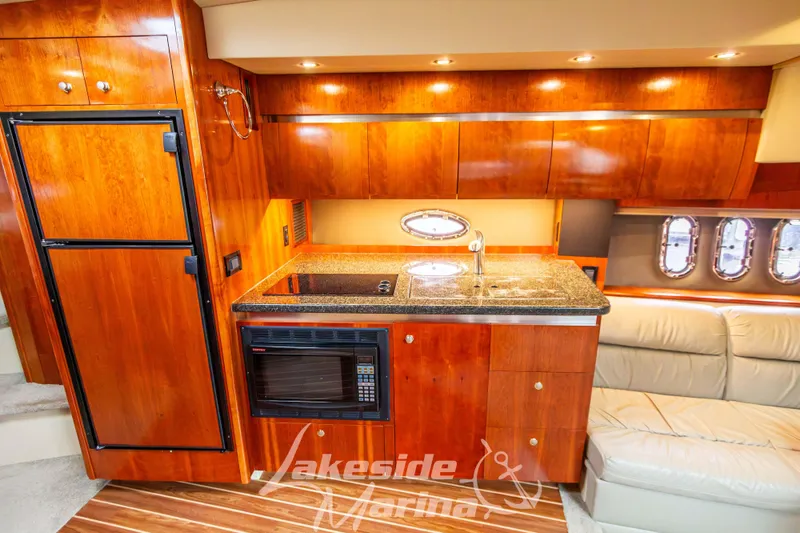 Slide: The Image of Luxurious 2006 Cruisers Yachts 420 Express interior kitchen with wood cabinetry and modern appliances. - 89
