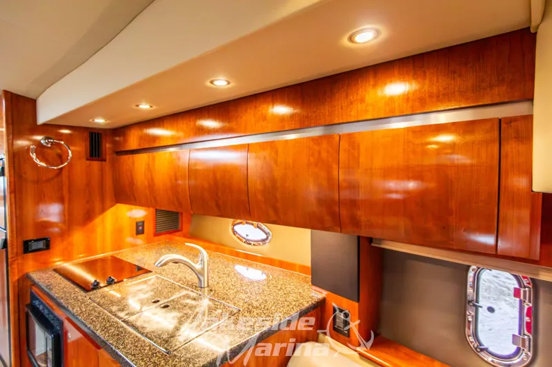 Slide: The Image of Luxurious 2006 Cruisers Yachts 420 Express kitchen with wood cabinetry and granite countertops. - 95
