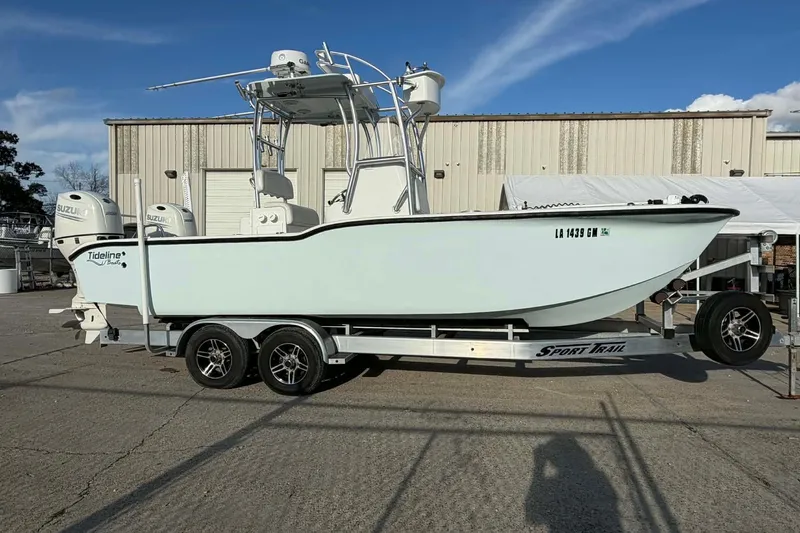 Slide: The Image of 2020 Tideline 235 Hybrid boat on trailer, parked outdoors near industrial building. - 2