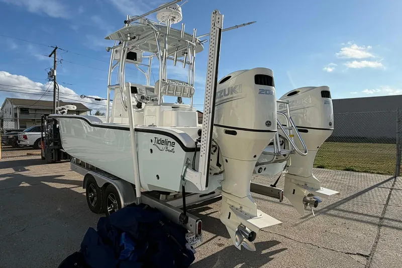 Slide: The Image of 2020 Tideline 235 Hybrid boat with dual Suzuki engines, parked outdoors. - 5