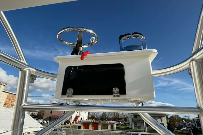 Slide: The Image of 2020 Tideline 235 Hybrid boat console with steering wheel and controls under clear blue sky. - 8