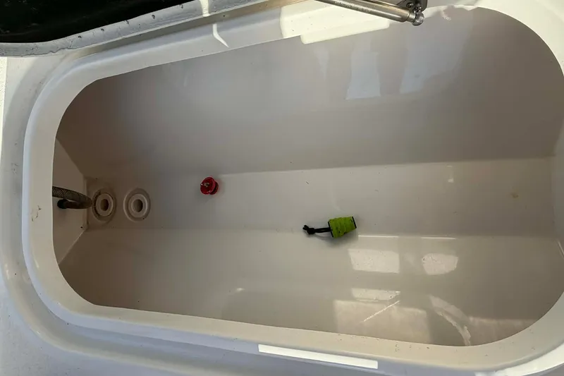 Slide: The Image of Livewell interior of 2020 Tideline 235 Hybrid boat, featuring drain and plug. - 9