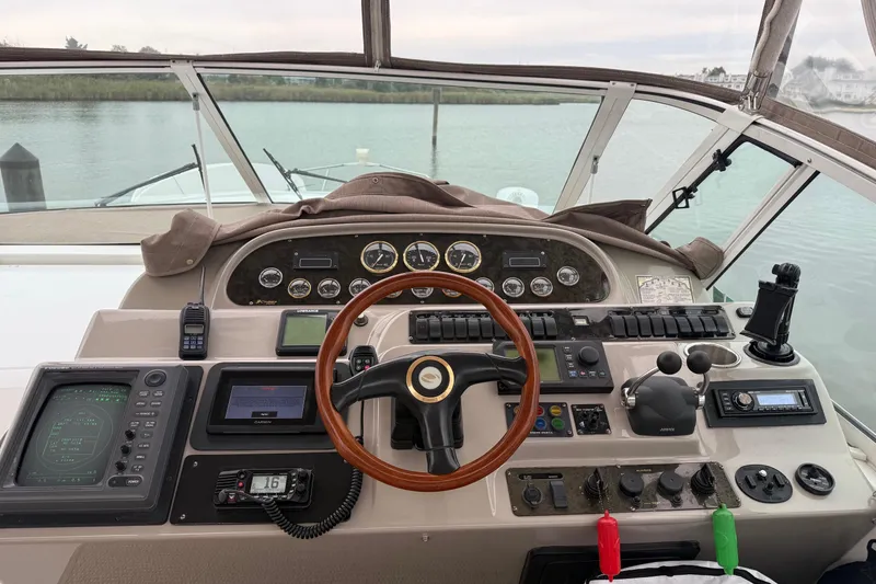 Slide: The Image of 2001 Cruisers 4450 ACMY yacht helm with navigation instruments and wooden steering wheel. - 10