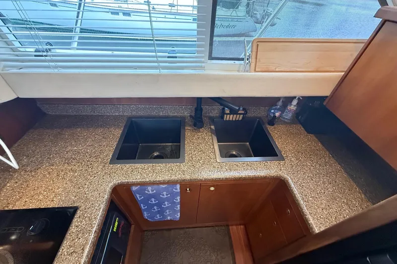 Slide: The Image of 2001 Cruisers 4450 ACMY yacht kitchen with dual sinks and granite countertops. - 15