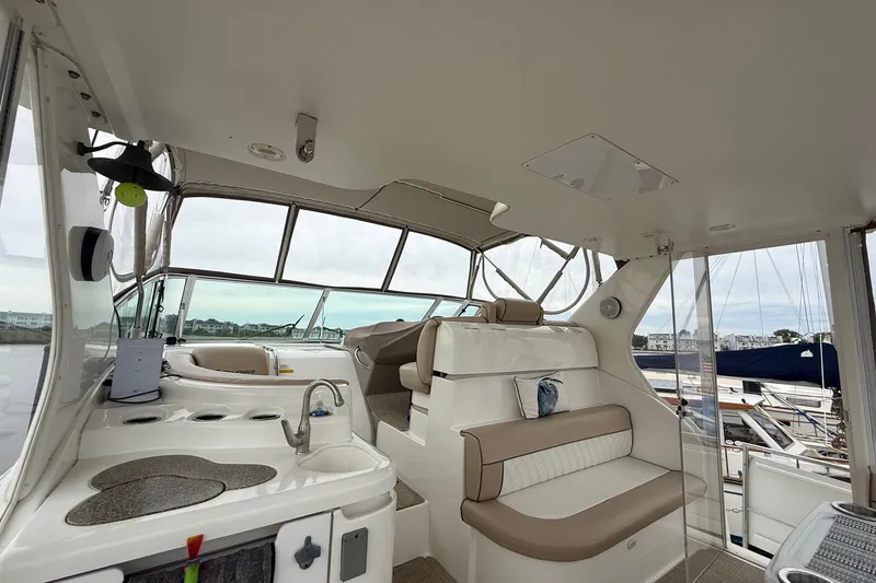 Slide: The Image of 2001 Cruisers 4450 ACMY yacht interior with seating and helm, docked at marina. - 8