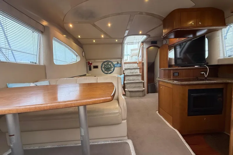 Slide: The Image of Luxurious interior of 2001 Cruisers 4450 ACMY yacht with dining area and entertainment center. - 14