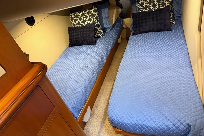 Slide: The Image of 2001 Cruisers 4450 ACMY cabin with twin beds, blue bedding, and decorative pillows. - 27