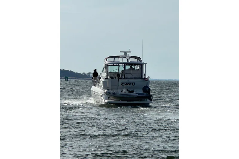 Slide: The Image of 2001 Cruisers 4450 ACMY yacht cruising on open water, rear view. - 5