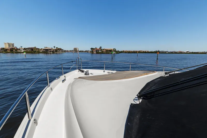 Slide: The Image of Bow view of a Lazzara yacht cruising on a calm, scenic waterway. - 16