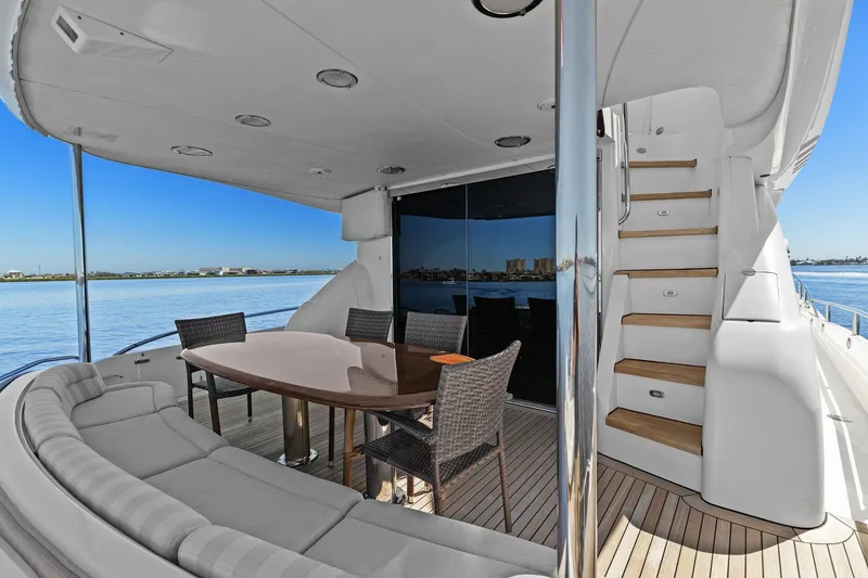 Slide: The Image of Luxurious Lazzara yacht deck with seating, table, and staircase overlooking serene waters. - 20