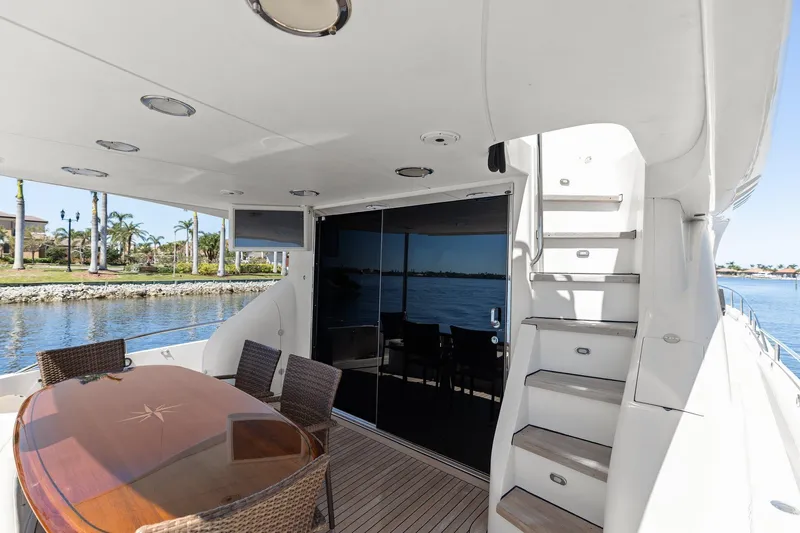 Slide: The Image of Luxurious Lazzara yacht deck with dining area, stairs, and waterfront view. - 21