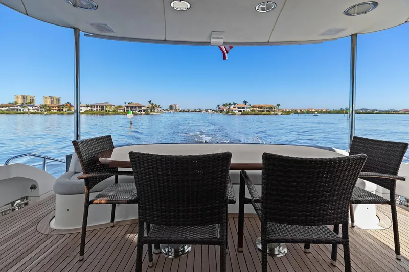 Slide: The Image of Luxury Lazzara yacht deck with wicker chairs, overlooking serene waterfront homes. - 27