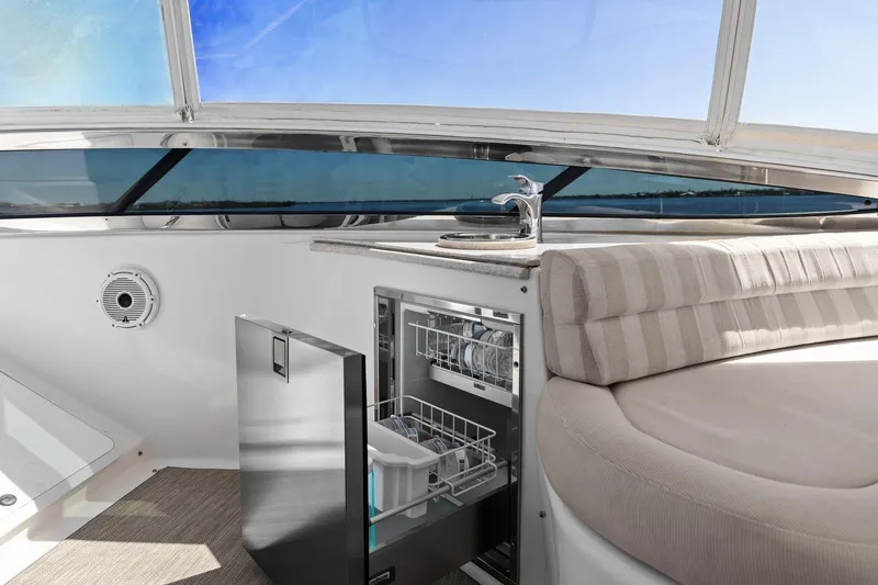Slide: The Image of Luxurious Lazzara yacht interior with dishwasher, sink, and cushioned seating under a clear blue sky. - 35