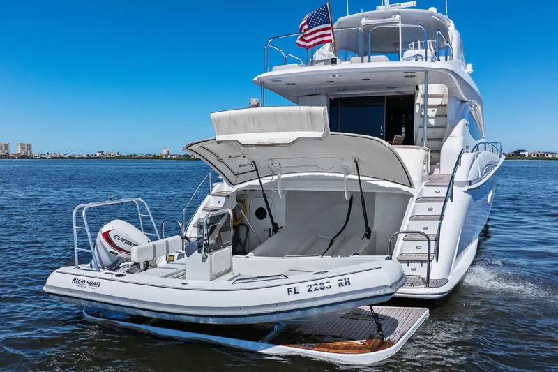 Slide: The Image of Luxury Lazzara yacht with tender boat, American flag, and scenic waterfront view. - 7