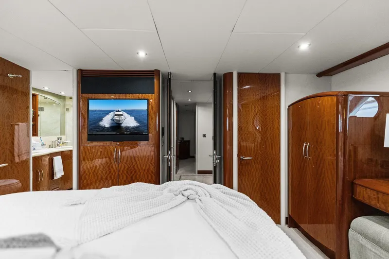 Slide: The Image of Luxurious Lazzara yacht bedroom with wood paneling, TV, and ensuite bathroom. - 70