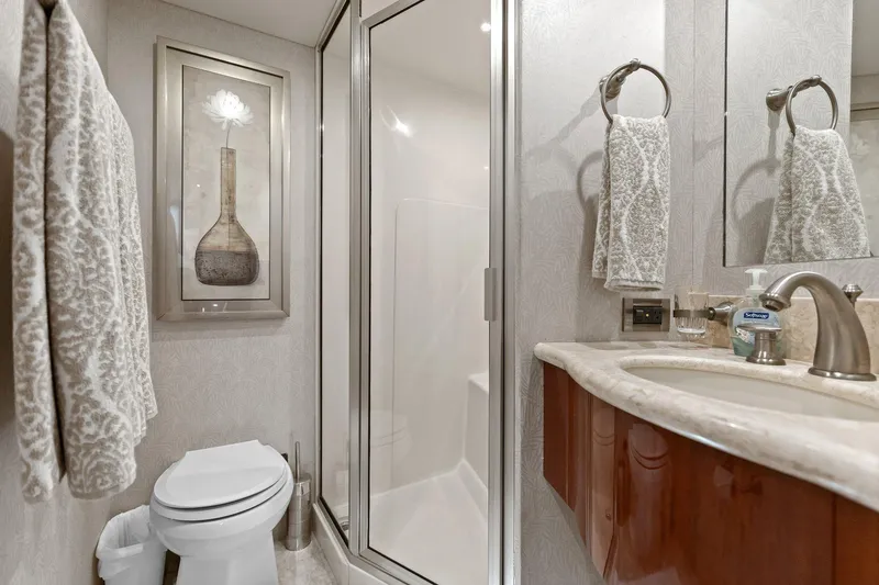 Slide: The Image of Luxurious Lazzara yacht bathroom with elegant decor, featuring a shower, sink, and framed artwork. - 75