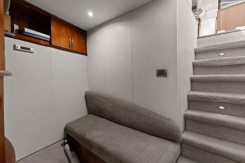 Slide: The Image of Lazzara yacht interior with gray seating, wooden cabinets, and carpeted stairs. - 85