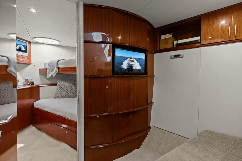 Slide: The Image of Luxurious Lazzara yacht interior with wood paneling, cozy bed, and wall-mounted TV. - 87