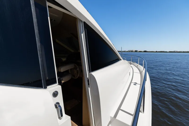 Slide: The Image of Side view of a Lazzara yacht on calm waters under a clear blue sky. - 92