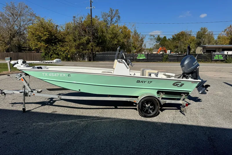 Slide: The Image of 2023 G3 Bay 17 boat on trailer, parked outdoors under clear blue sky. - 1