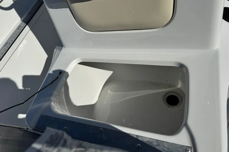 Slide: The Image of Open storage compartment on 2023 G3 Bay 17 boat, featuring a drain hole. - 15