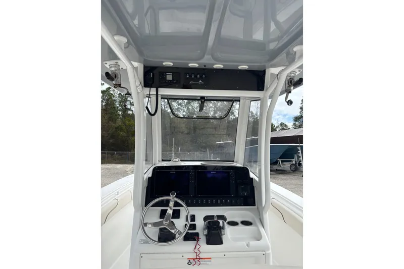 Slide: The Image of 2019 Sea Hunt Gamefish 27 Coffin Box boat console with steering wheel and controls. - 13