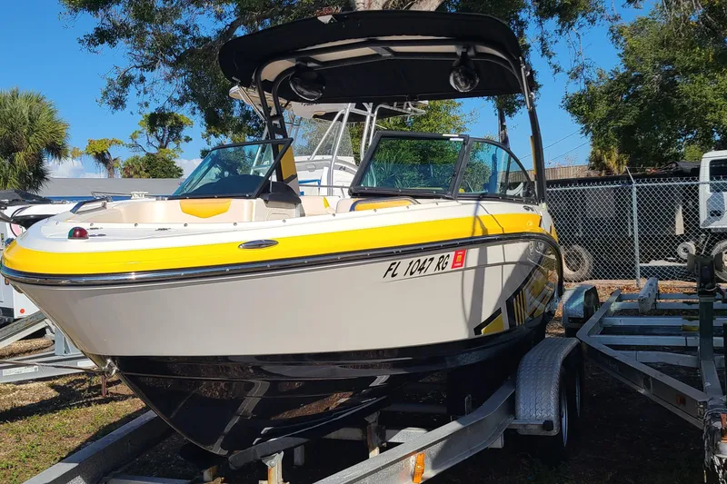 Slide: The Image of 2017 Chaparral Vortex 203 VRX boat with yellow accents on a trailer. - 2