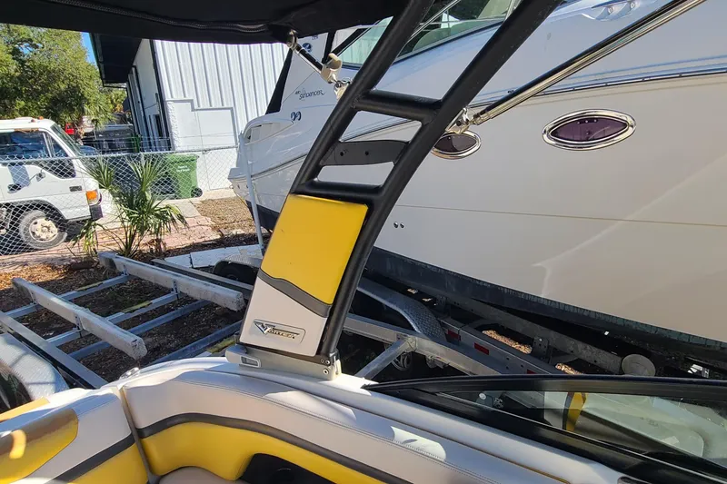 Slide: The Image of 2017 Chaparral Vortex 203 VRX boat interior with yellow accents, parked near another boat. - 22