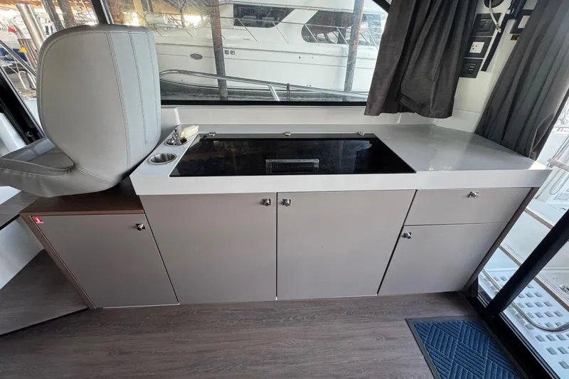 Slide: The Image of Interior of 2025 Beneteau Antares 11 Fly, featuring modern kitchen cabinetry and seating. - 10