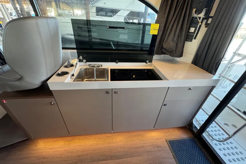 Slide: The Image of 2025 Beneteau Antares 11 Fly interior kitchen with sink and stove. - 11