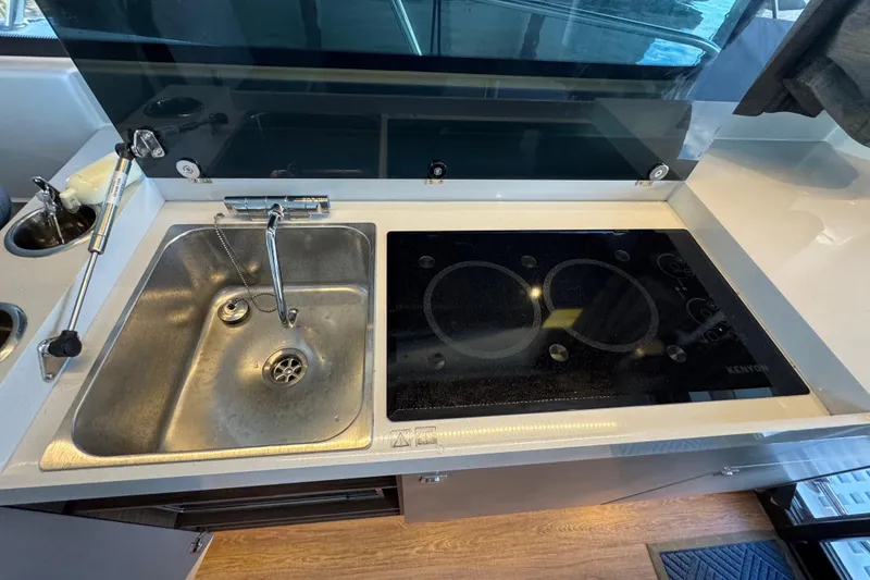 Slide: The Image of Modern kitchen in 2025 Beneteau Antares 11 Fly with sink and electric cooktop. - 12