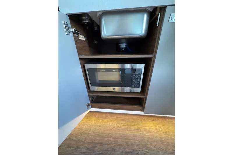 Slide: The Image of Microwave and sink in 2025 Beneteau Antares 11 Fly kitchen cabinet. - 14