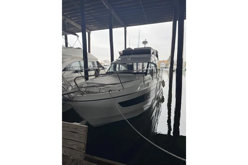 Slide: The Image of 2025 Beneteau Antares 11 Fly yacht docked in a marina under shelter. - 2