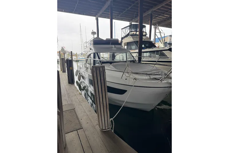 Slide: The Image of 2025 Beneteau Antares 11 Fly yacht docked in a marina under a covered area. - 3