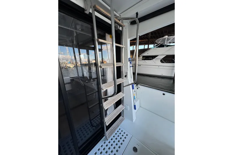Slide: The Image of 2025 Beneteau Antares 11 Fly yacht with ladder and marina view. - 6