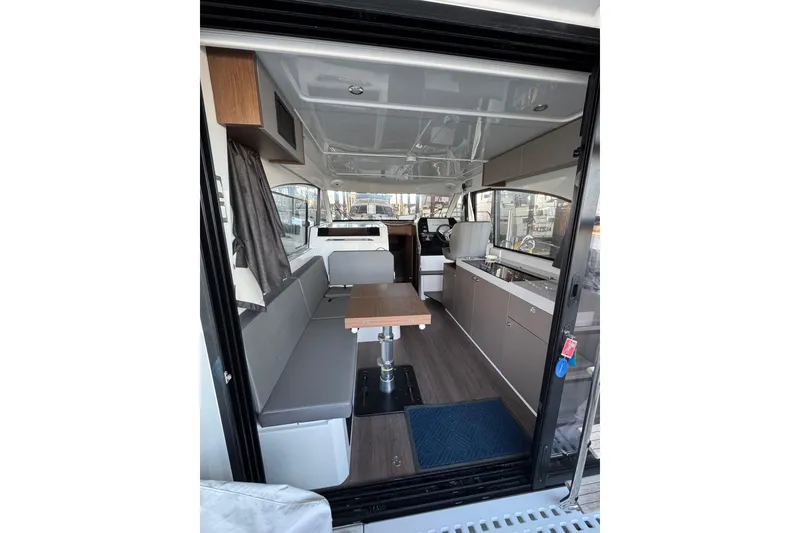 Slide: The Image of Interior of 2025 Beneteau Antares 11 Fly, featuring modern seating and kitchen area. - 7