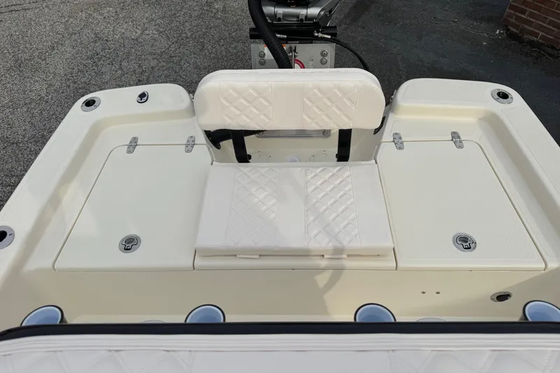 Slide: The Image of 2026 BlackJack 224 boat interior with white cushioned seating and storage compartments. - 19