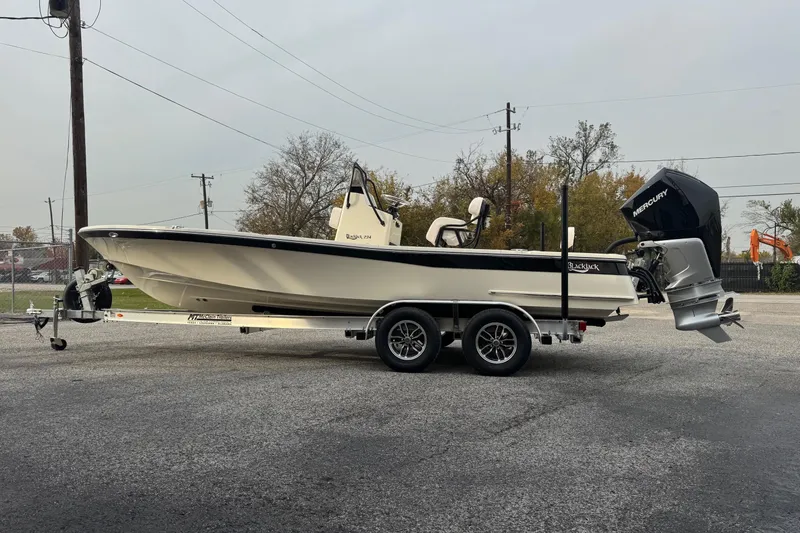 Slide: The Image of 2026 BlackJack 224 boat on trailer with Mercury outboard motor, parked outdoors. - 4