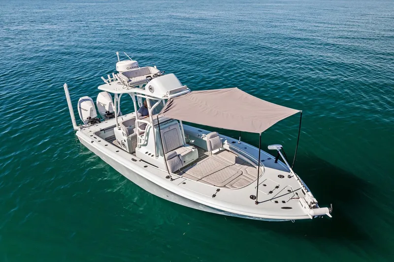 Slide: The Image of 2023 Barker Boatworks 26 Open on calm blue water, featuring a sunshade canopy. - 11